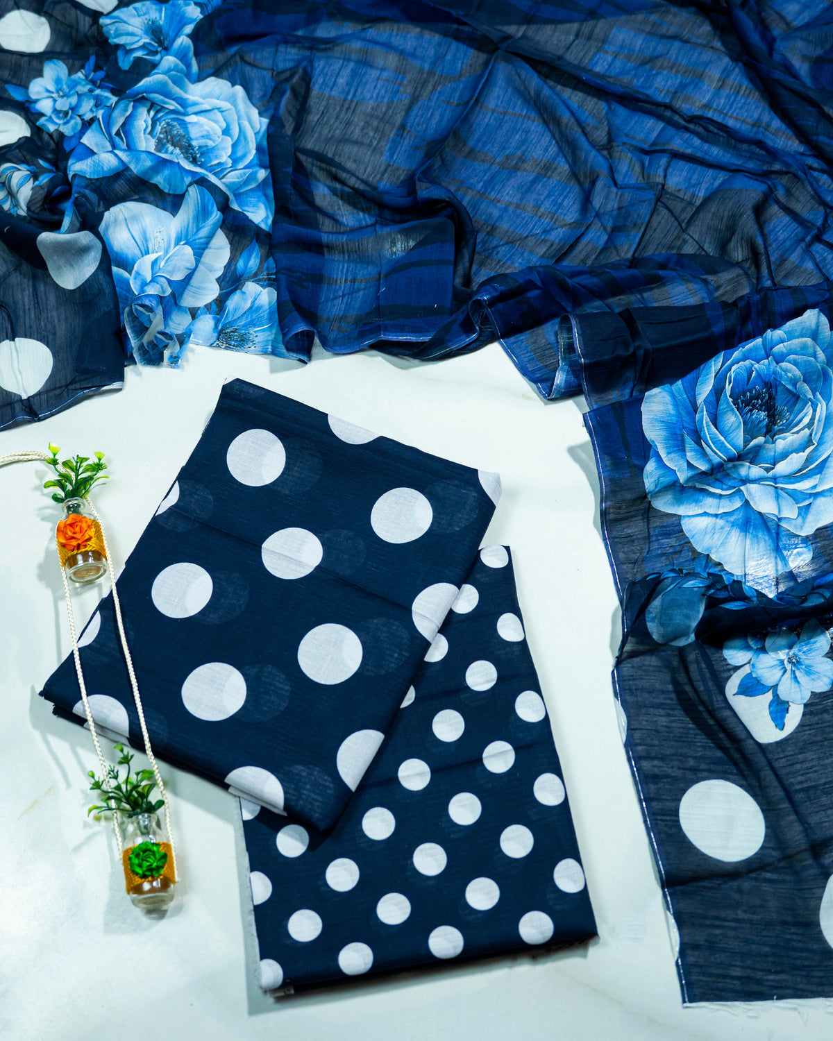Navy blue fabric with white polka dots and blue floral patterns on a white background