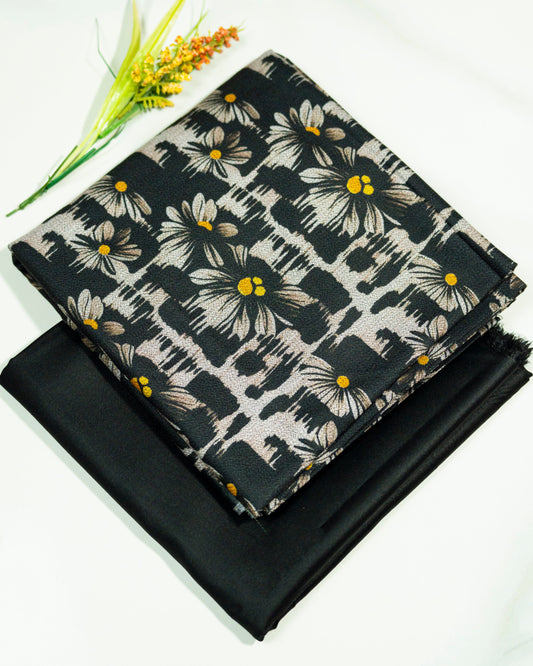 Floral fabric with yellow centers on a black background, folded and displayed.