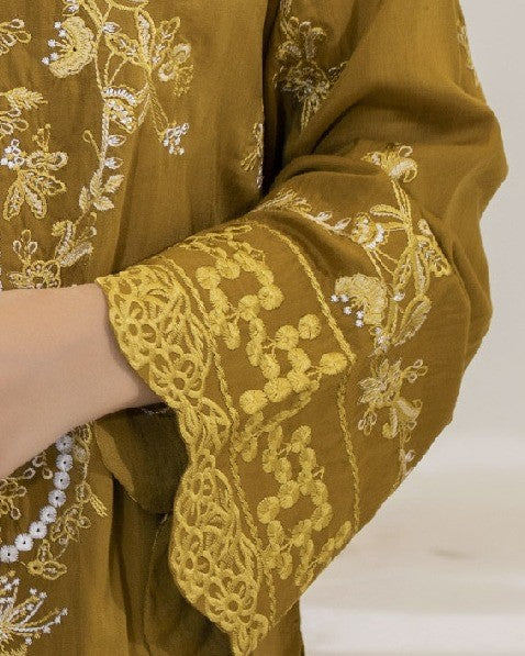 Brown fabric with intricate gold embroidery on a plain background