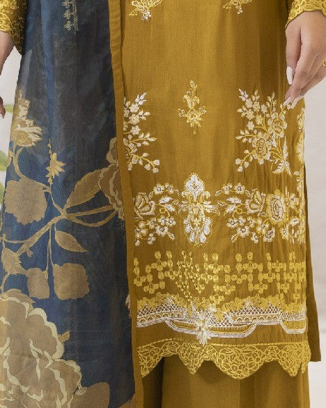 Close-up of a mustard yellow fabric with intricate white embroidery on a plain background