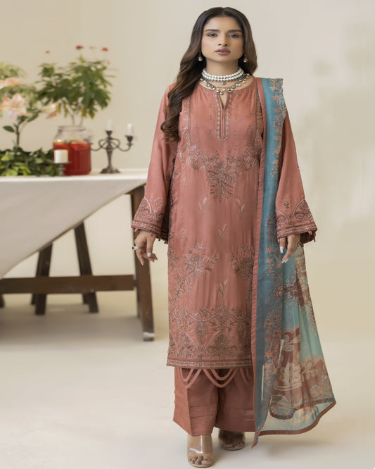 A woman wearing a brown embroidered shirt with floral patterns, a blue dupatta, and matching trousers.