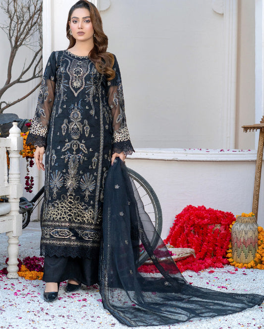 A woman wearing a black traditional dress with embroidered organza and silk details, including a dupatta and trousers.